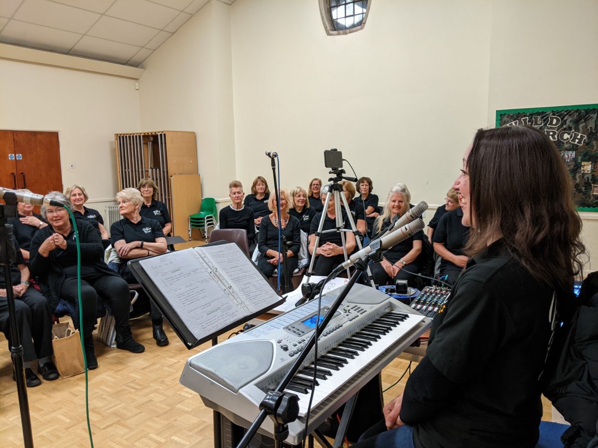 Lynne at the keyboard leading a Vocal Fun rehearsal